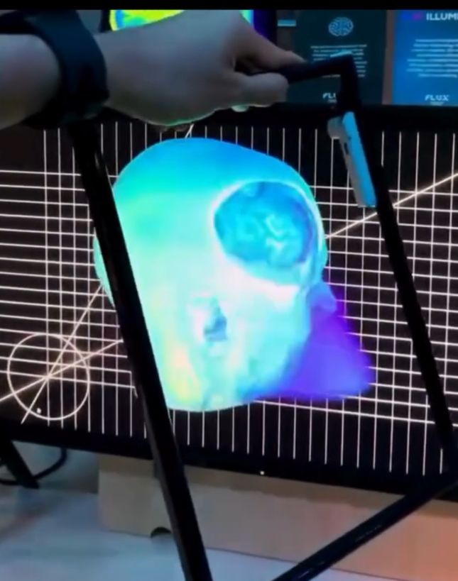 Demonstração do Slice-AR de Roy Rodenhaeuser em uma tela estereoscópica Illumetry IO, com moldura física rastreada atravessando o volume tridimensional de uma ressonância magnética